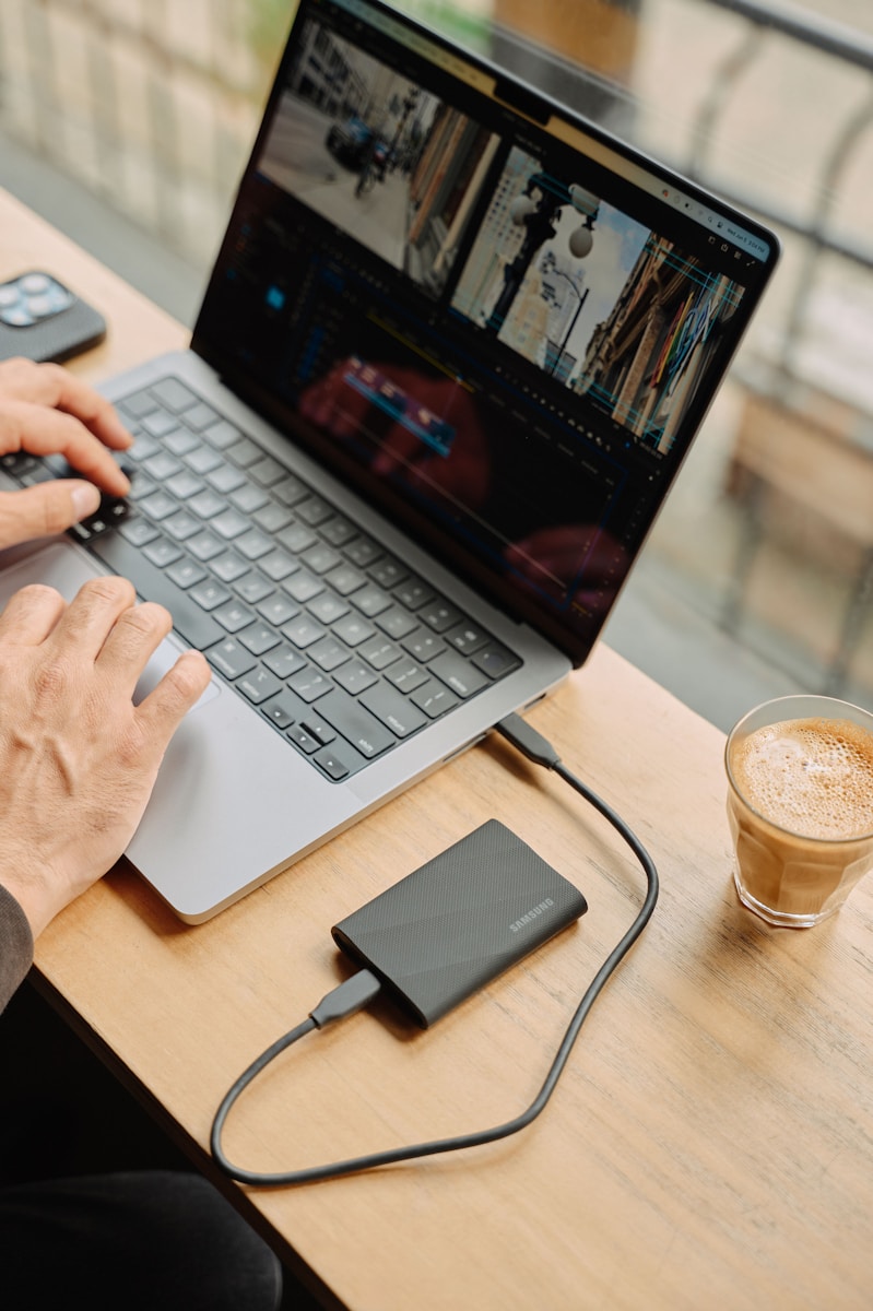 A man sitting at a table using a laptop computer